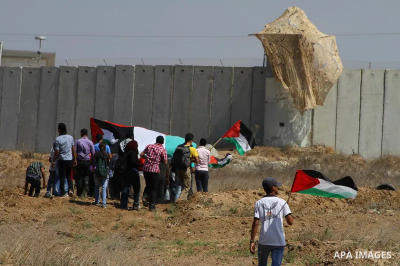 Palestinian and foreign activists take part in a rally in support of the Palestinian UN bid for statehood near the fence separating Israel from the Gaza Strip, in Beit Hanun, on September 20, 2011. The Palestinians are p...