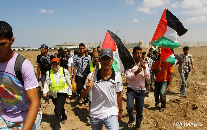 Palestinian and foreign activists take part in a rally in support of the Palestinian UN bid for statehood near the fence separating Israel from the Gaza Strip, in Beit Hanun, on September 20, 2011. The Palestinians are p...