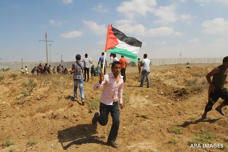 Palestinian and foreign activists take part in a rally in support of the Palestinian UN bid for statehood near the fence separating Israel from the Gaza Strip, in Beit Hanun, on September 20, 2011. The Palestinians are p...