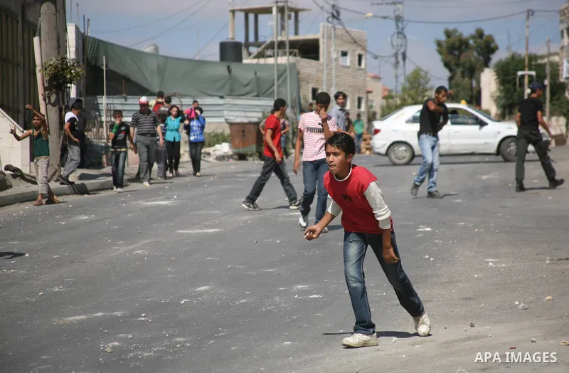 Palestinian youths throw stones towards Israeli soldiers during a protest in the West Bank village of Beit Omar, near Hebron on 20 September 2011. President Mahmoud Abbas intends to make a bid on 23 September for United...