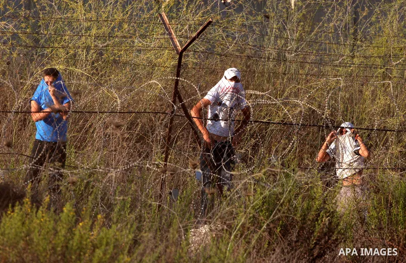 Masked Jewish settler boys from the Israeli West bank settlement of Bet El, throw stones at Palestinians Near the refugee camp of Jalazoun in the West Bank city of Ramallah on September 20, 2011. Reports state that Pales...