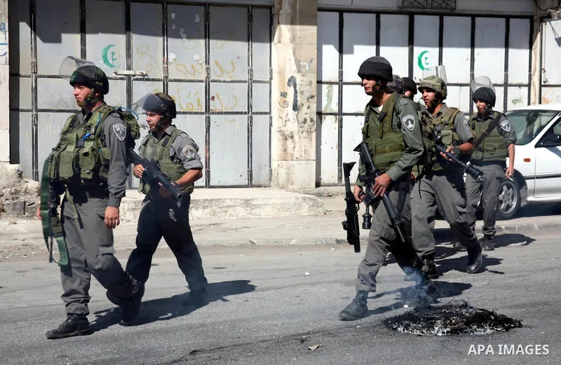 Israeli soldiers take position during clashes with Palestinians following a protest in the West Bank city of Hebron 21 September 2011, as Palestinian president Mahmud Abbas prepares to submit a formal request for Palesti...