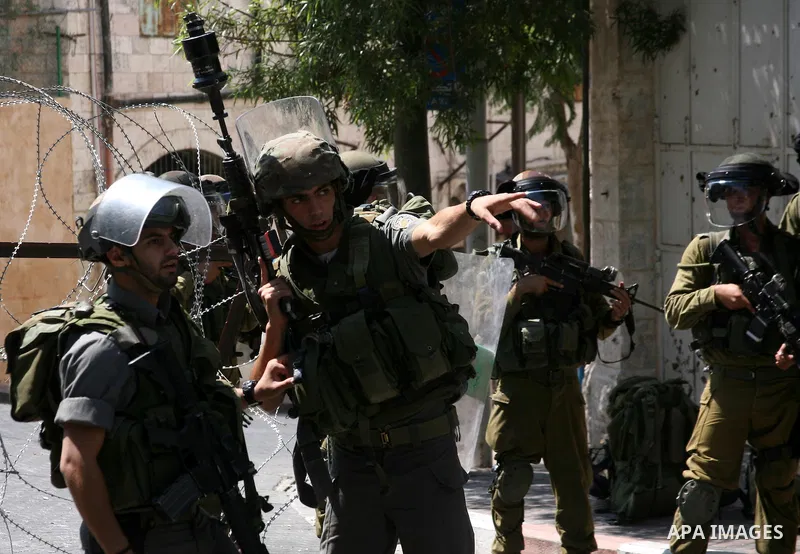 Israeli soldiers take position during clashes with Palestinians following a protest in the West Bank city of Hebron 21 September 2011, as Palestinian president Mahmud Abbas prepares to submit a formal request for Palesti...