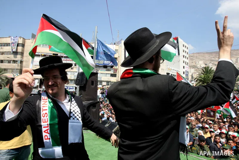 Members of Neturei Karta, a small faction of ultra-Orthodox Jews who oppose Israel's existence,wave Palestinian flags to express support for the Palestinian bid for statehood recognition at the United Nations as thousand...