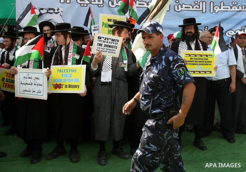 Members of Neturei Karta, a small faction of ultra-Orthodox Jews who oppose Israel's existence, hold placards to express support for the Palestinian bid for statehood recognition at the United Nations as thousands of Pal...