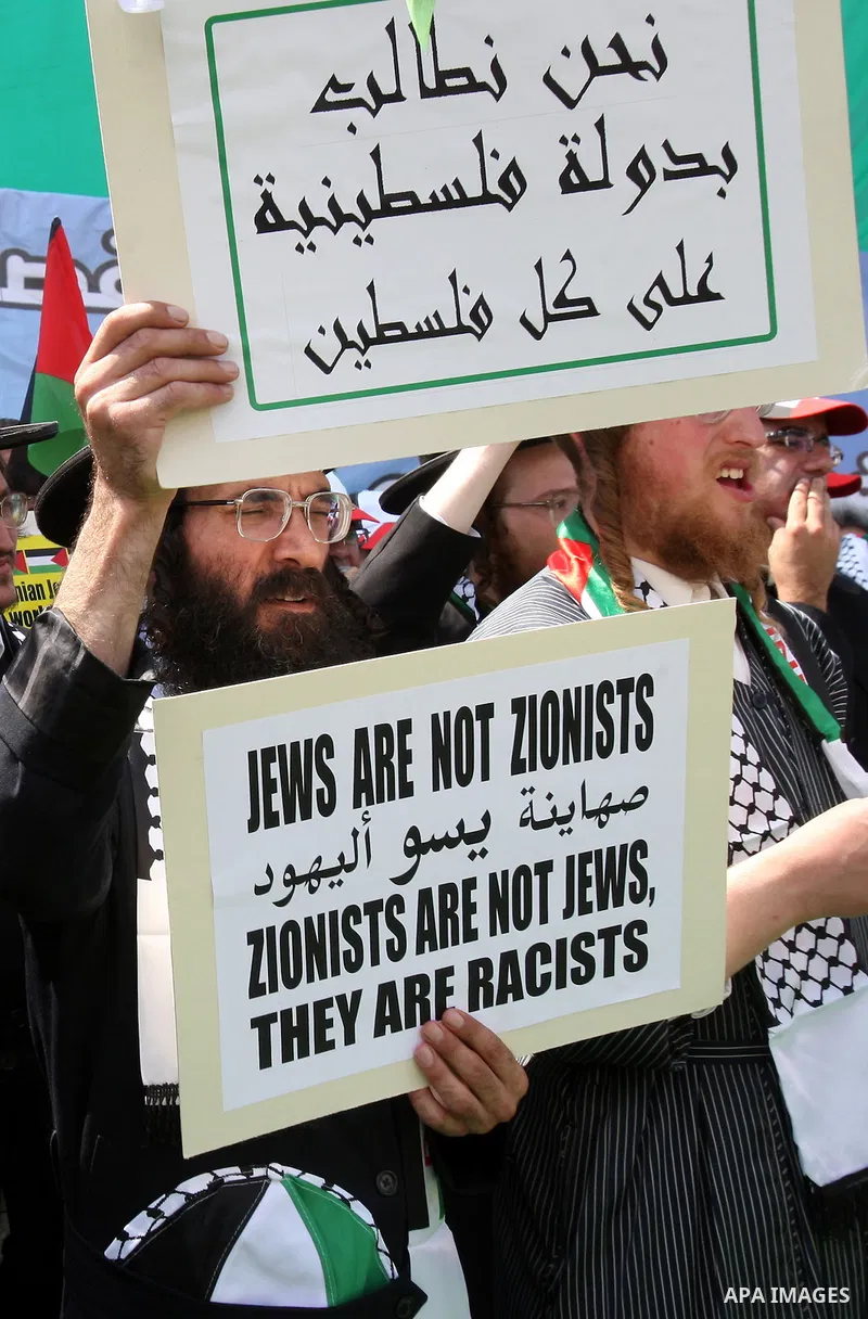 Members of Neturei Karta, a small faction of ultra-Orthodox Jews who oppose Israel's existence, hold placards to express support for the Palestinian bid for statehood recognition at the United Nations as thousands of Pal...