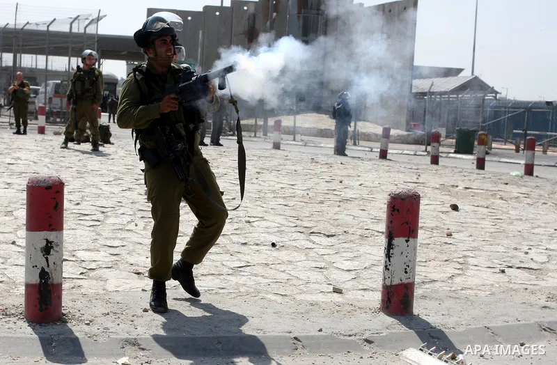 An Israeli soldier fires tear gas canister during clashes with Palestinian protesters at the Qalandia checkpoint between the West Bank city of Ramallah and Jerusalem, Wednesday, Sept. 21, 2011. Palestinians clashed with...