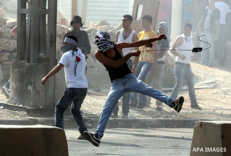 Palestinian protesters throw stones at Israeli soldiers during clashes at the Qalandia checkpoint between the West Bank city of Ramallah and Jerusalem, Wednesday, Sept. 21, 2011. Palestinians clashed with Israeli securit...
