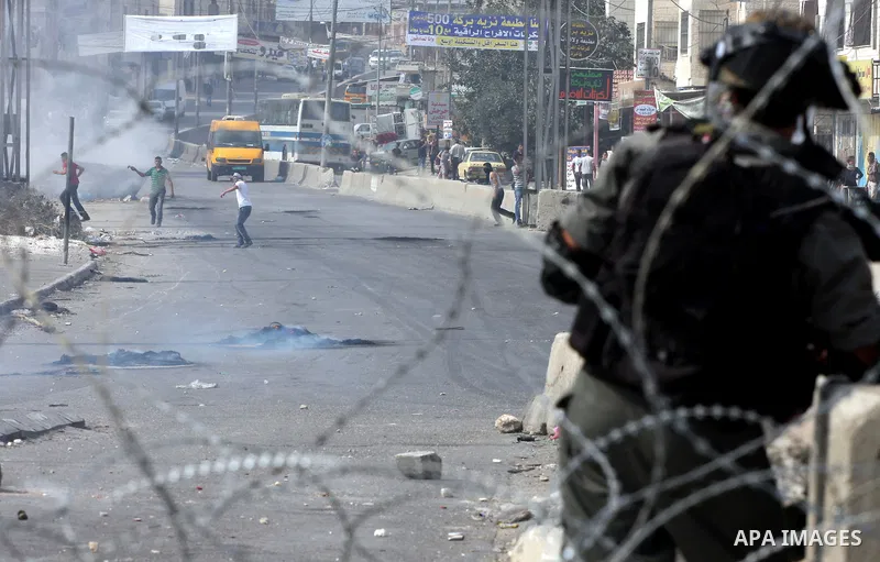 Palestinian protesters throw stones at Israeli soldiers during clashes at the Qalandia checkpoint between the West Bank city of Ramallah and Jerusalem, Wednesday, Sept. 21, 2011. Palestinians clashed with Israeli securit...