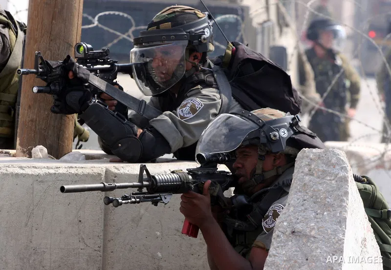 Israeli soldiers take position during clashes with Palestinian protesters at the Qalandia checkpoint between the West Bank city of Ramallah and Jerusalem, Wednesday, Sept. 21, 2011. Palestinians clashed with Israeli secu...
