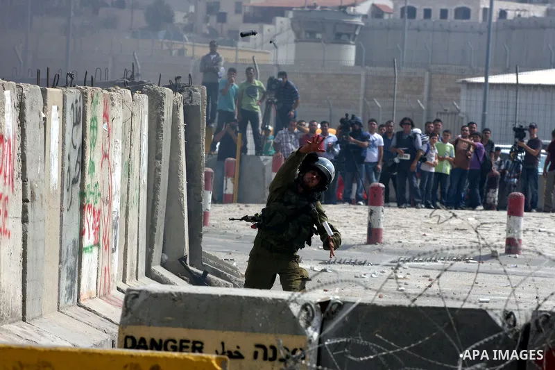 An Israeli soldier hurls tear gas canister during clashes with Palestinian protesters at the Qalandia checkpoint between the West Bank city of Ramallah and Jerusalem, Wednesday, Sept. 21, 2011. Palestinians clashed with...