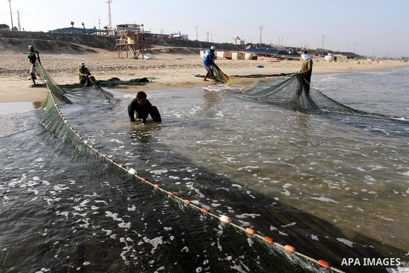 Palestinian fishermen pull their nets at the beach of Gaza city on Sep. 22, 2011. Palestinians hoped that the blockade is lifted from the sea, and setting "Palestine state 194", representing their hope to become the 194t...