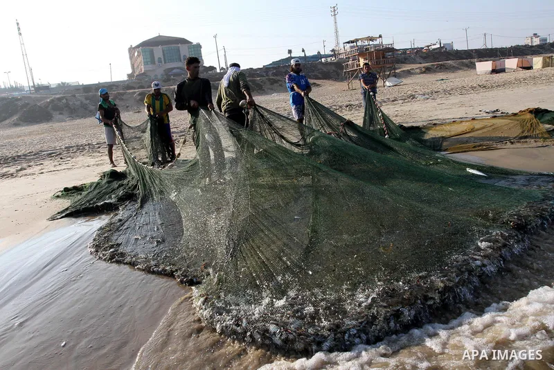 Palestinian fishermen pull their nets at the beach of Gaza city on Sep. 22, 2011. Palestinians hoped that the blockade is lifted from the sea, and setting "Palestine state 194", representing their hope to become the 194t...