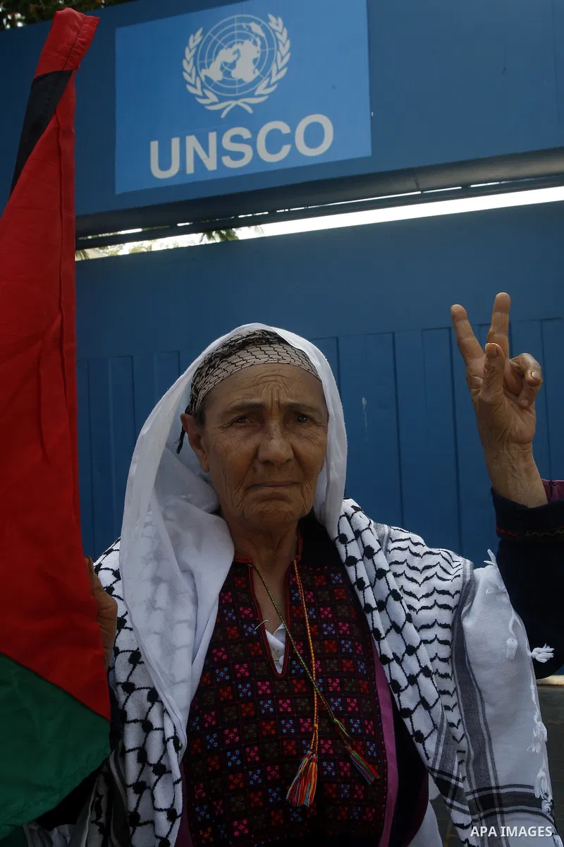 A Palestinian woman raises the victory sign and waving the national flag during a demonstration in support of Palestinian leader Mahmud Abbas' bid for statehood recognition at the United Nations on September 22, 2011 in...