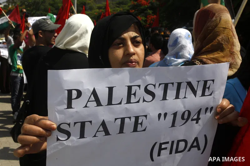 Palestinian women chant slogans and wave their national flag during a demonstration in support of Palestinian leader Mahmud Abbas' bid for statehood recognition at the United Nations on September 22, 2011 in Gaza City. P...
