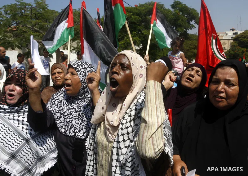 Palestinian women chant slogans and wave their national flag during a demonstration in support of Palestinian leader Mahmud Abbas' bid for statehood recognition at the United Nations on September 22, 2011 in Gaza City. P...
