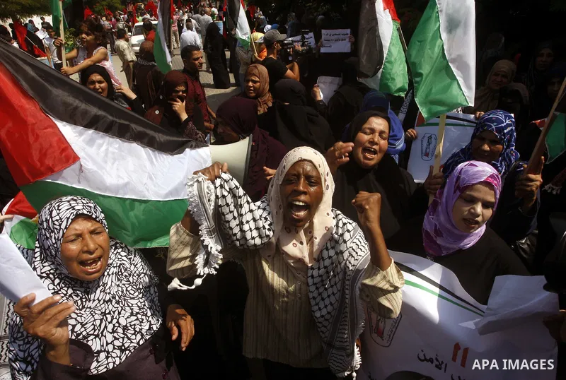 Palestinian women chant slogans and wave their national flag during a demonstration in support of Palestinian leader Mahmud Abbas' bid for statehood recognition at the United Nations on September 22, 2011 in Gaza City. P...