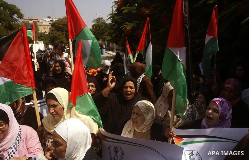 Palestinian women chant slogans and wave their national flag during a demonstration in support of Palestinian leader Mahmud Abbas' bid for statehood recognition at the United Nations on September 22, 2011 in Gaza City. P...