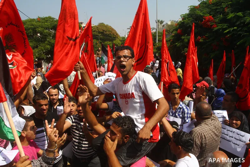 Palestinian men chant slogans and wave their national flag during a demonstration in support of Palestinian leader Mahmud Abbas' bid for statehood recognition at the United Nations on September 22, 2011 in Gaza City. Pho...