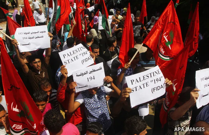 Palestinian men chant slogans and wave their national flag during a demonstration in support of Palestinian leader Mahmud Abbas' bid for statehood recognition at the United Nations on September 22, 2011 in Gaza City. Pho...