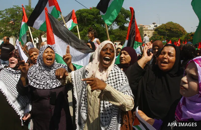 Palestinian women chant slogans and wave their national flag during a demonstration in support of Palestinian leader Mahmud Abbas' bid for statehood recognition at the United Nations on September 22, 2011 in Gaza City. P...