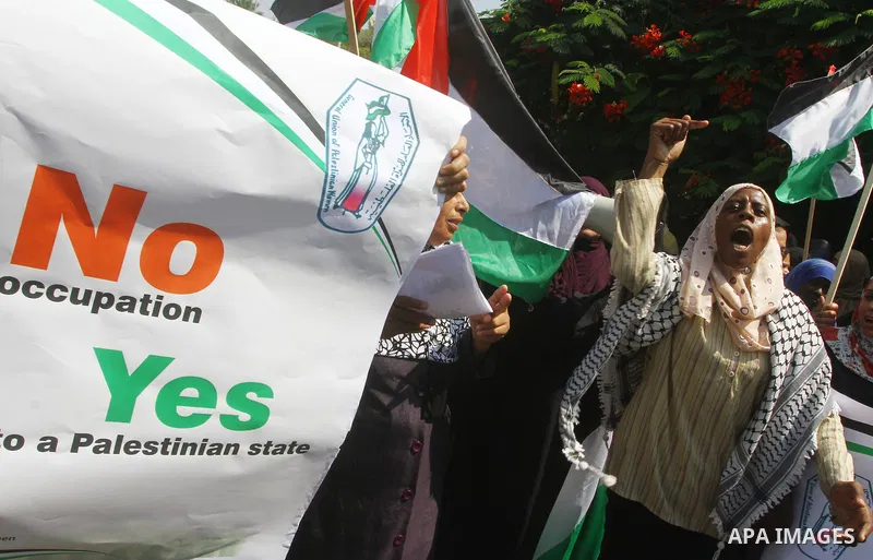 Palestinian women chant slogans and wave their national flag during a demonstration in support of Palestinian leader Mahmud Abbas' bid for statehood recognition at the United Nations on September 22, 2011 in Gaza City. P...