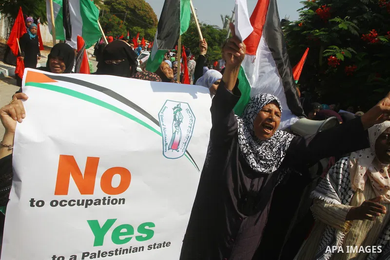 Palestinian women chant slogans and wave their national flag during a demonstration in support of Palestinian leader Mahmud Abbas' bid for statehood recognition at the United Nations on September 22, 2011 in Gaza City. P...