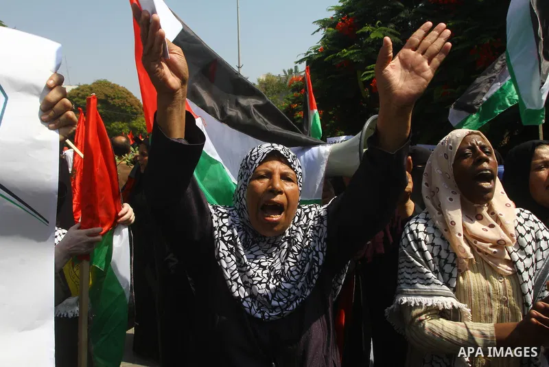 Palestinian women chant slogans and wave their national flag during a demonstration in support of Palestinian leader Mahmud Abbas' bid for statehood recognition at the United Nations on September 22, 2011 in Gaza City. P...