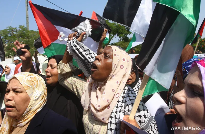 Palestinian women chant slogans and wave their national flag during a demonstration in support of Palestinian leader Mahmud Abbas' bid for statehood recognition at the United Nations on September 22, 2011 in Gaza City. P...