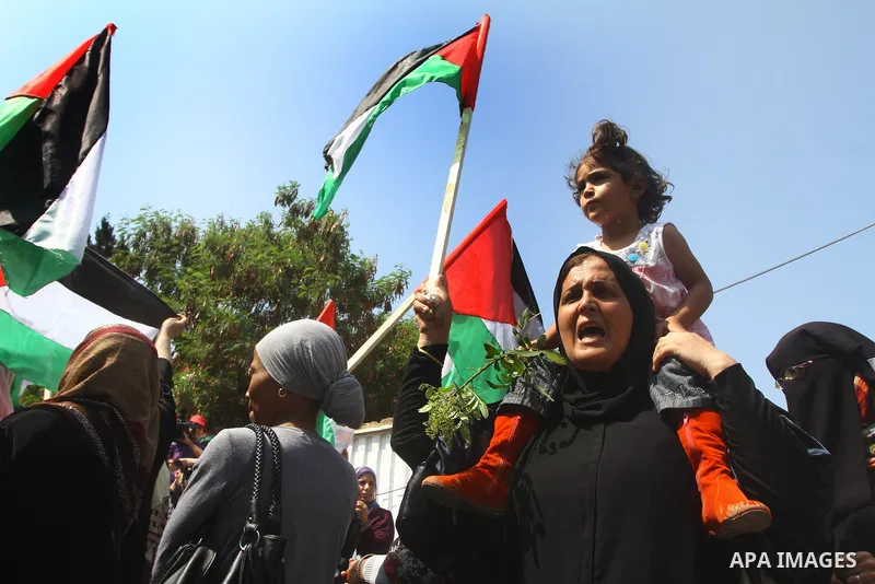 Palestinian women chant slogans and wave their national flag during a demonstration in support of Palestinian leader Mahmud Abbas' bid for statehood recognition at the United Nations on September 22, 2011 in Gaza City. P...