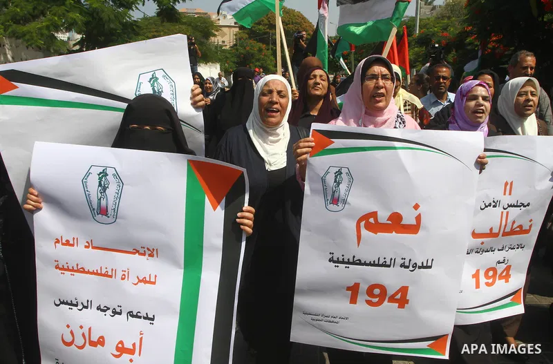 Palestinian women chant slogans and wave their national flag during a demonstration in support of Palestinian leader Mahmud Abbas' bid for statehood recognition at the United Nations on September 22, 2011 in Gaza City. P...