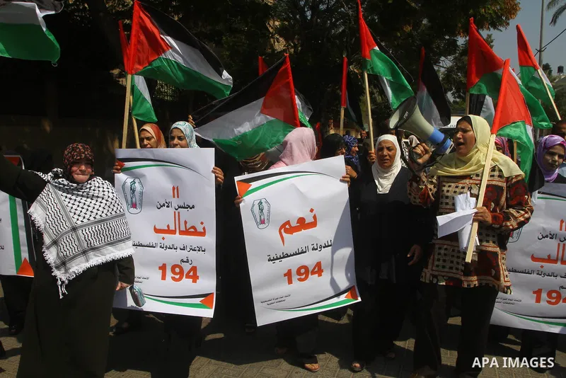 Palestinian women chant slogans and wave their national flag during a demonstration in support of Palestinian leader Mahmud Abbas' bid for statehood recognition at the United Nations on September 22, 2011 in Gaza City. P...