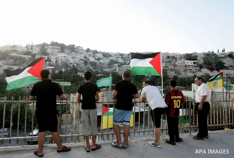 Palestinians wave their national flag at a street on September 22, 2011 in the east Jerusalem neighborhood of Silwan. Palestinians are preparing to submit a formal request to become the 194th member of the United Nations...