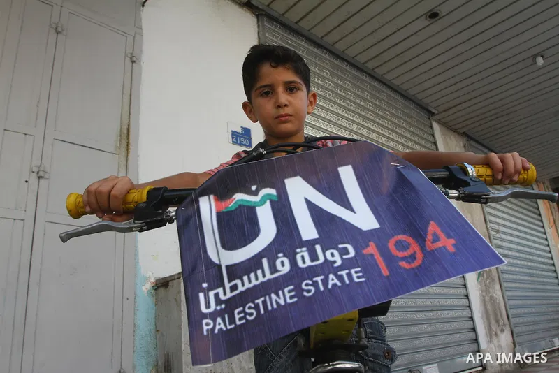 A Palestinian boy rides a bicycle decorated with a sign supporting the Palestinians' bid in the United Nations for statehood recognition, on September 23, 2011 in Gaza City. Palestinian president Mahmud Abbas will presen...