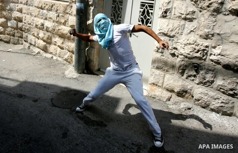 A Palestinian youth throws stones toward Israeli border police during clashes in the east Jerusalem neighborhood of Ras al-Amud on September 23, 2011, just hours before their president, Mahmoud Abbas, was to deliver his...