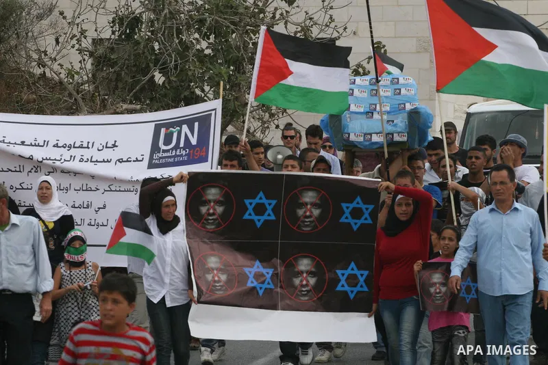 Palestinian protestors hold a banner in support of the Palestinian UN bid for statehood during a weekly protest in the West Bank village of Nabi Saleh, near Ramallah September 23, 2011. Israeli security forces were on hi...