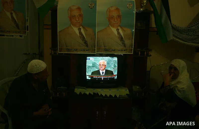 A Palestinian family watches as their president Mahmud Abbas addresses the General Assembly of the United Nations, in Gaza City on September 23, 2011 where he called on the UN to admit a state of Palestine as a full memb...