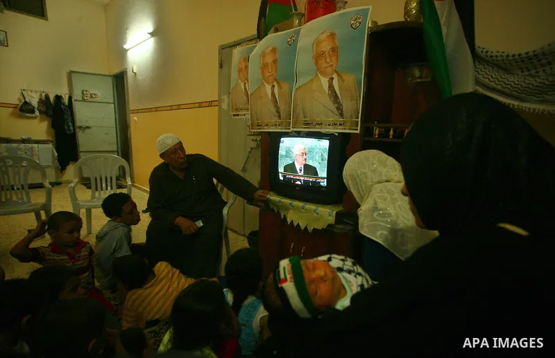 A Palestinian family watches as their president Mahmud Abbas addresses the General Assembly of the United Nations, in Gaza City on September 23, 2011 where he called on the UN to admit a state of Palestine as a full memb...