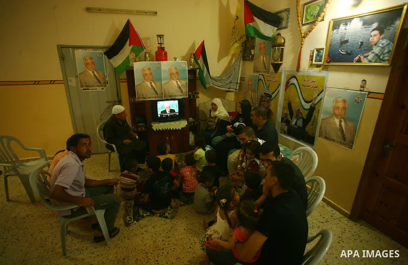 A Palestinian family watches as their president Mahmud Abbas addresses the General Assembly of the United Nations, in Gaza City on September 23, 2011 where he called on the UN to admit a state of Palestine as a full memb...