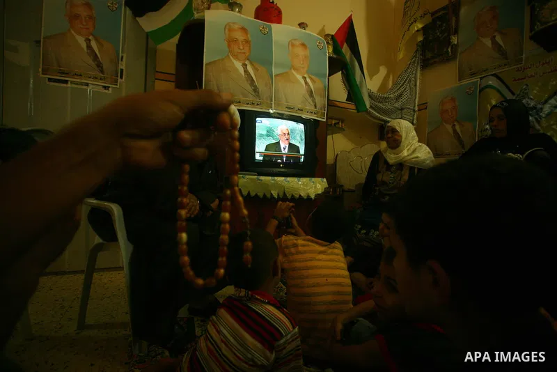 A Palestinian family watches as their president Mahmud Abbas addresses the General Assembly of the United Nations, in Gaza City on September 23, 2011 where he called on the UN to admit a state of Palestine as a full memb...