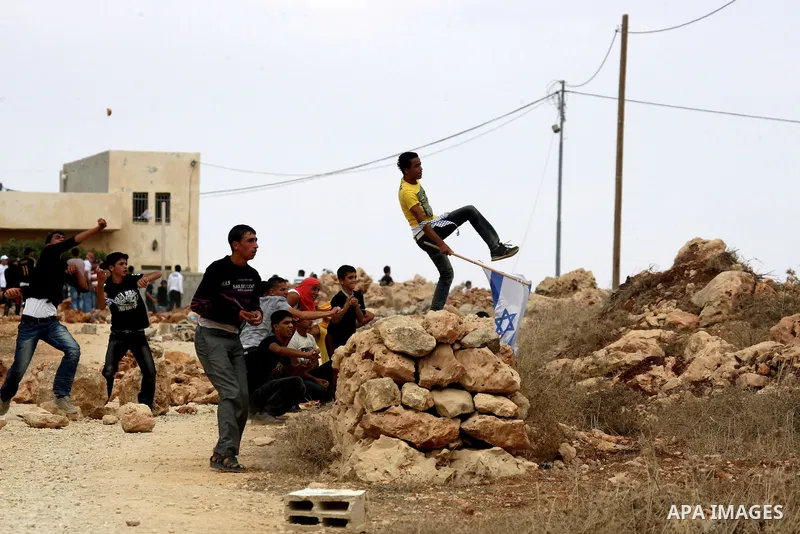 Palestinians throw stones toward Israeli troops during clashes in the West Bank village of Qusra, south of Nablus, on September 23, 2011. A Palestinian man was shot dead by Israeli troops in clashes which erupted after s...