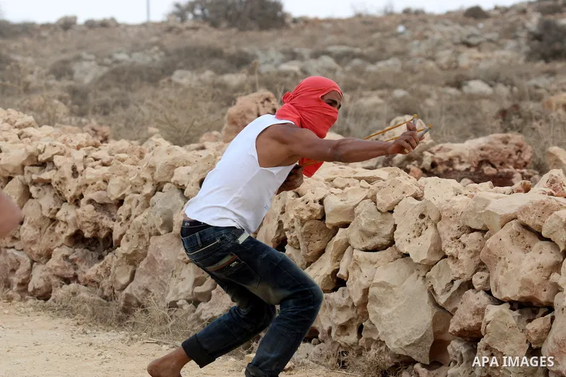Palestinians throw stones toward Israeli troops during clashes in the West Bank village of Qusra, south of Nablus, on September 23, 2011. A Palestinian man was shot dead by Israeli troops in clashes which erupted after s...