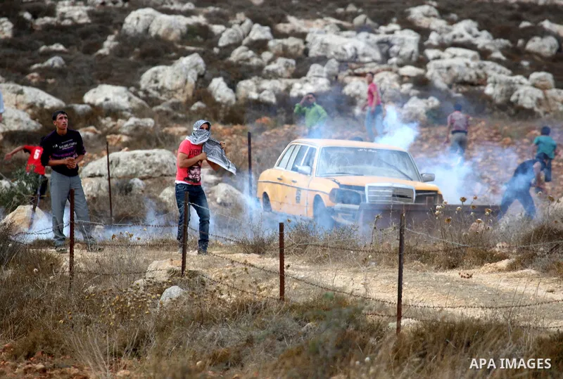 Palestinians throw stones toward Israeli troops during clashes in the West Bank village of Qusra, south of Nablus, on September 23, 2011. A Palestinian man was shot dead by Israeli troops in clashes which erupted after s...