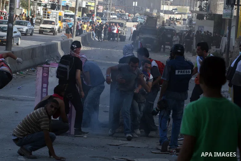 Palestinian men throw stones at Israeli soldiers during riots at the Qalandia checkpoint near Ramallah, on 23 September 2011. Reports state that Israeli security services were on high alert across the country, poised to...