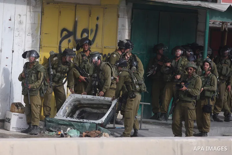 Israeli soldiers take a position during clashes with Palestinian men at the Qalandia checkpoint near Ramallah, on 23 September 2011. Reports state that Israeli security services were on high alert across the country, poi...