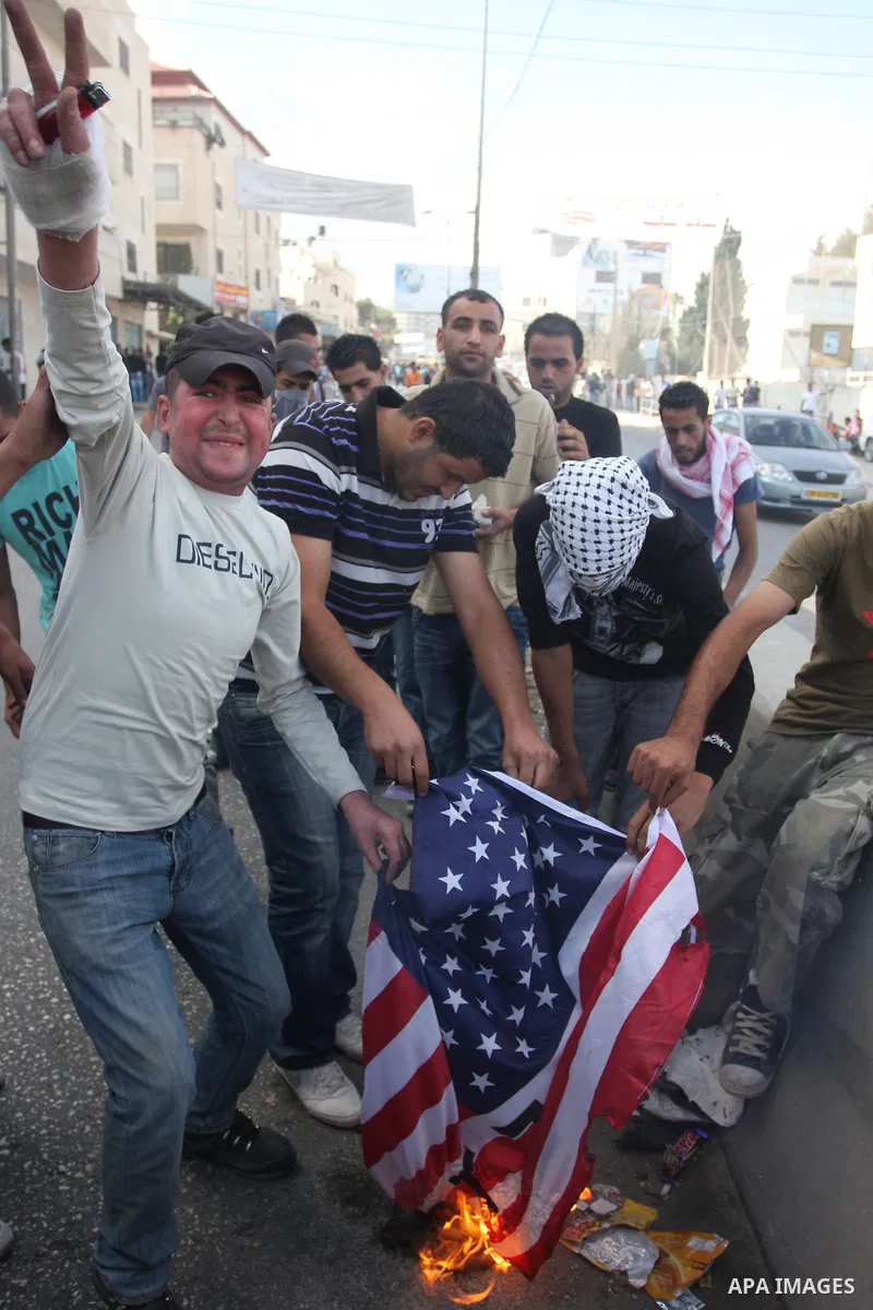 Palestinian protesters burn an U.S.A flag during riots at the Qalandia checkpoint near Ramallah, on 23 September 2011. Reports state that Israeli security services were on high alert across the country, poised to respond...