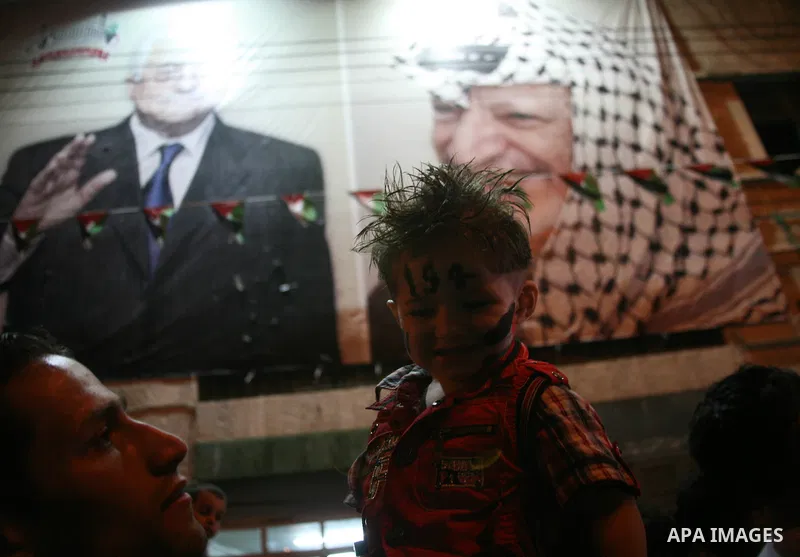 Palestinians watch their President Mahmoud Abbas on TV as he delivers his speech at the General Assembly of the United Nations, in the West Bank city of Hebron, Friday, Sept. 23, 2011. Photo by Mamoun Wazwaz