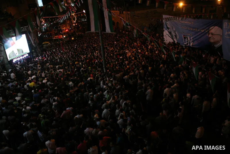 Palestinians watch their President Mahmoud Abbas on TV as he delivers his speech at the General Assembly of the United Nations, in the West Bank city of Hebron, Friday, Sept. 23, 2011. Photo by Mamoun Wazwaz