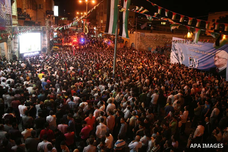 Palestinians watch their President Mahmoud Abbas on TV as he delivers his speech at the General Assembly of the United Nations, in the West Bank city of Hebron, Friday, Sept. 23, 2011. Photo by Mamoun Wazwaz