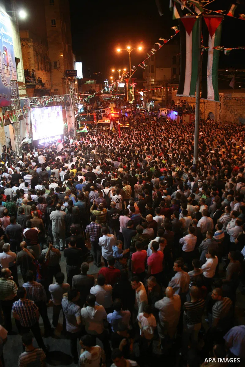Palestinians watch their President Mahmoud Abbas on TV as he delivers his speech at the General Assembly of the United Nations, in the West Bank city of Hebron, Friday, Sept. 23, 2011. Photo by Mamoun Wazwaz